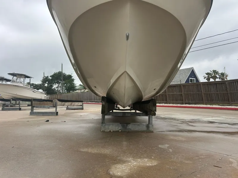 Slide: The Image of 1983 Boston Whaler 25 Outrage boat on a stand, viewed from the front, outdoors. - 9