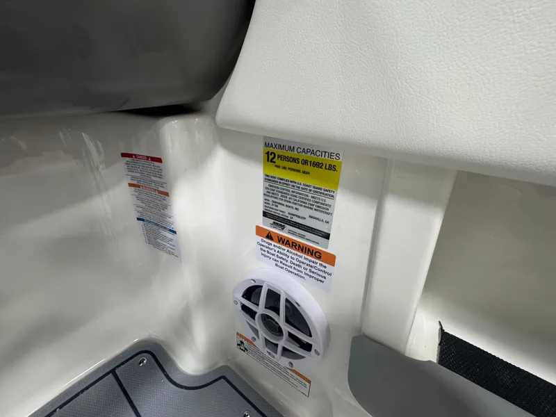 Slide: The Image of 2025 Chaparral 21 SSi boat interior showing capacity and warning labels. - 16