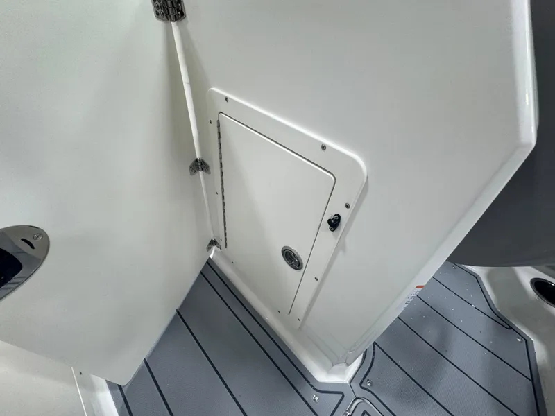 Slide: The Image of 2025 Chaparral 21 SSi boat interior with storage compartment and gray flooring. - 18