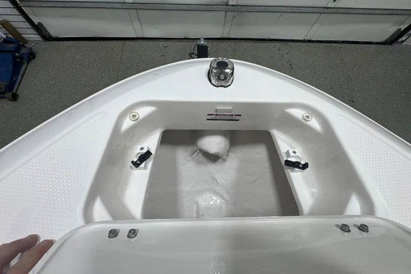 Slide: The Image of 2025 Chaparral 21 SSi boat storage compartment, open and empty, in a garage setting. - 21