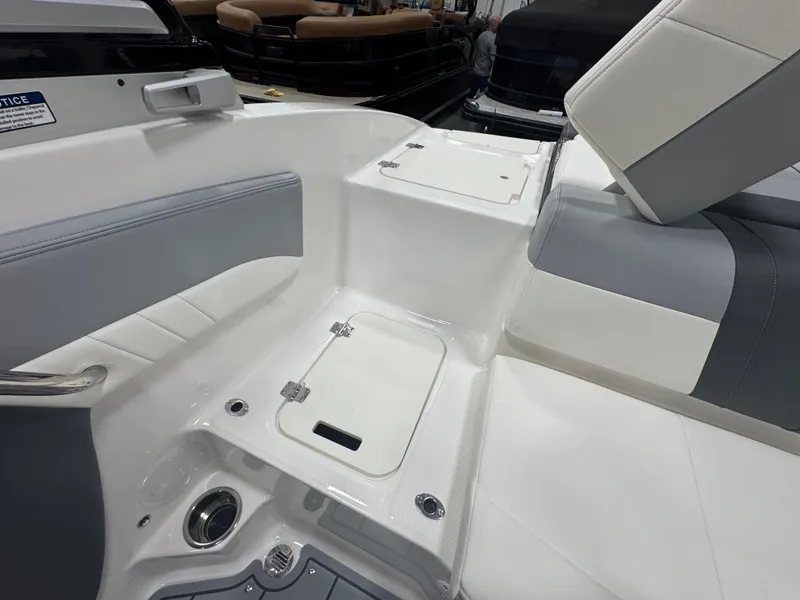 Slide: The Image of 2025 Chaparral 21 SSi boat interior with white and gray seating and storage compartments. - 9