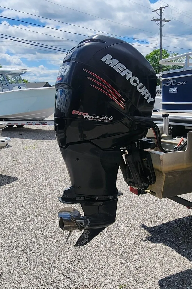 Slide: The Image of 2014 Sun Tracker Regency Edition 254 XP3 with Mercury outboard motor in a marina setting. - 10