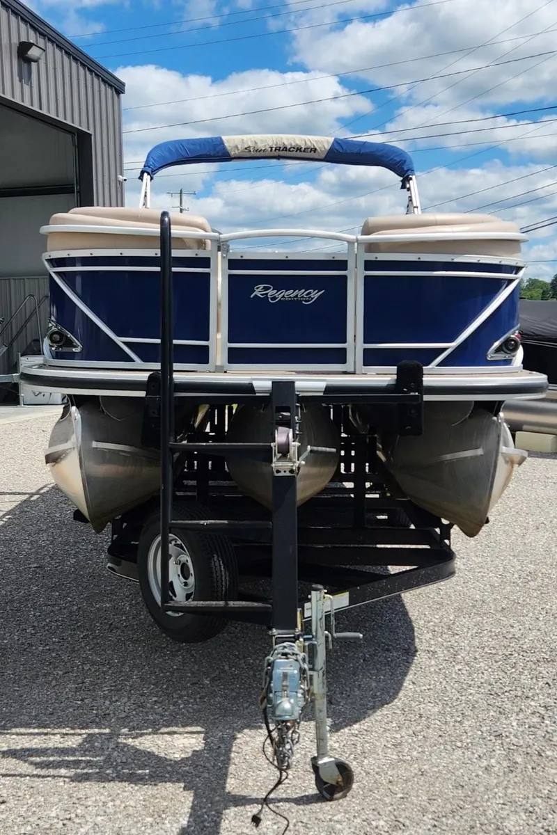 Slide: The Image of 2014 Sun Tracker Regency Edition 254 XP3 pontoon boat on trailer, parked outdoors. - 2