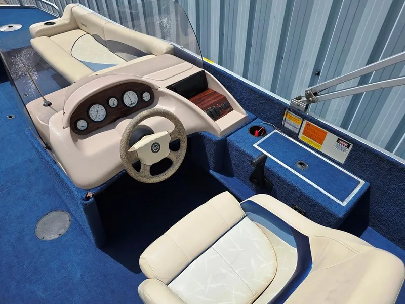 Slide: The Image of Interior of a 1997 Lowe LS 2220 boat with blue carpet and beige seating. - 2
