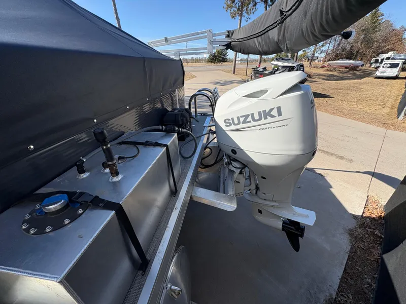 Slide: The Image of 2025 Custom Maui 160 Cruise boat with Suzuki outboard motor, parked on a sunny day. - 5