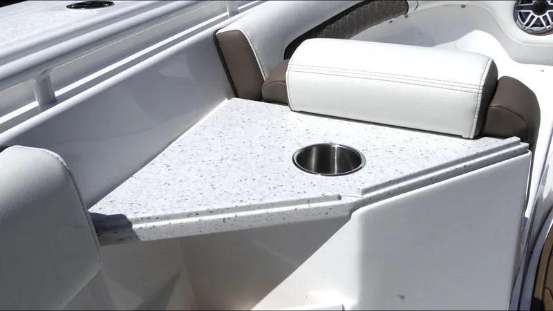 Slide: The Image of 2025 Tidewater 282 CC Adventure boat interior with white seating and a speckled table featuring a cup holder. - 30