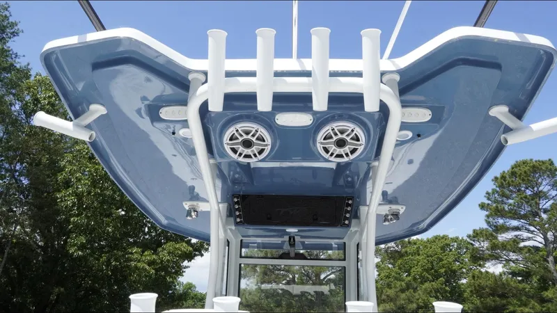 Slide: The Image of 2025 Tidewater 282 CC Adventure boat with blue T-top and rod holders. - 32