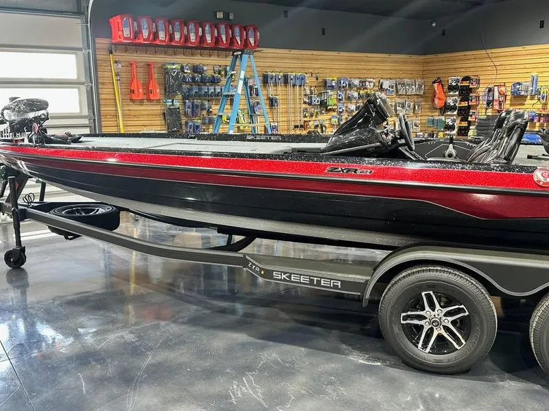 Slide: The Image of 2025 Skeeter ZXR 21 boat in showroom, featuring sleek black and red design. - 3