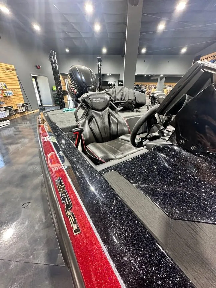 Slide: The Image of 2025 Skeeter ZXR 21 boat interior with sleek black and red design in showroom. - 5