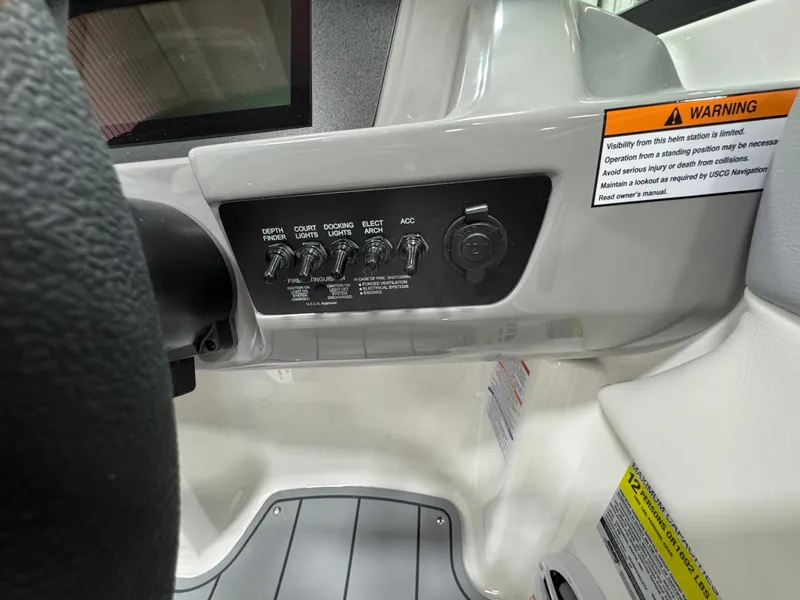 Slide: The Image of Control panel of 2025 Chaparral 21 SSi boat with warning labels and switches. - 17