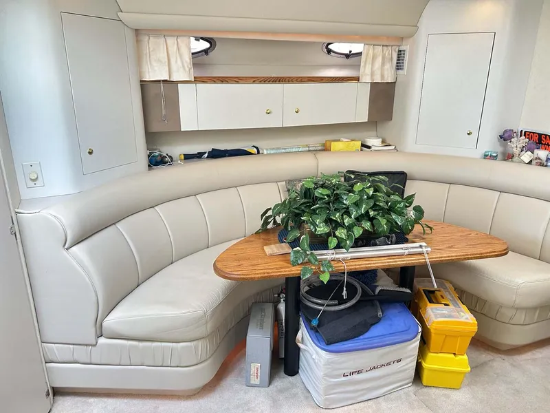 Slide: The Image of 1997 Cruisers Yachts 4270 Esprit interior with curved seating and wooden table. - 10