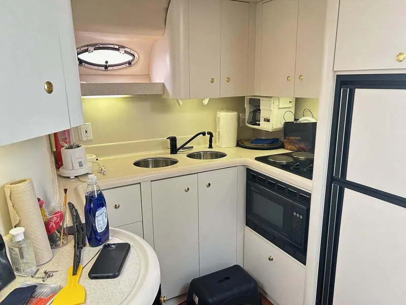 Slide: The Image of 1997 Cruisers Yachts 4270 Esprit kitchen with dual sinks, microwave, and compact appliances. - 11