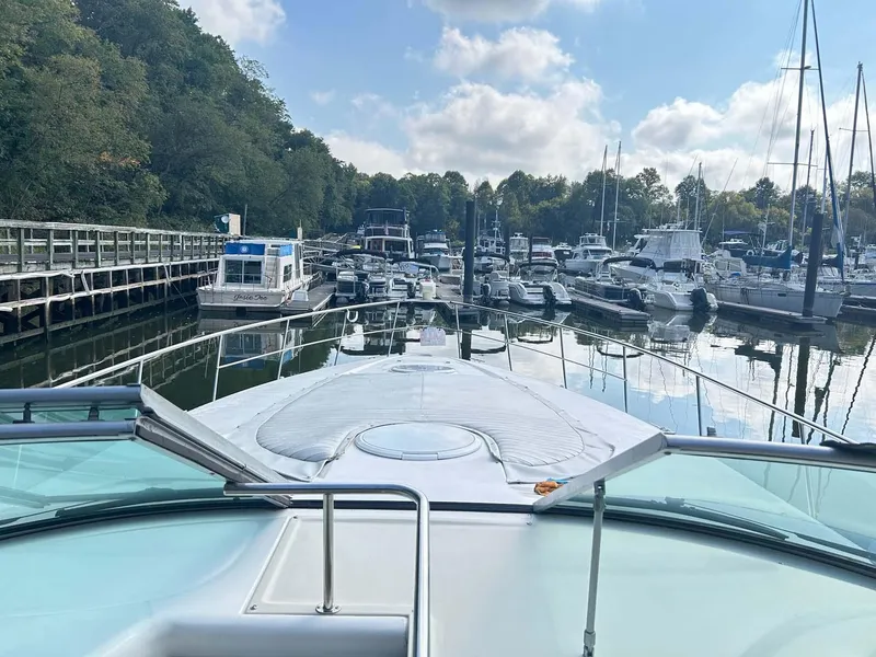 Slide: The Image of 1997 Cruisers Yachts 4270 Esprit docked in a serene marina with surrounding boats. - 5