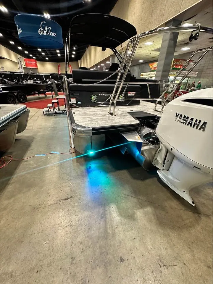 Slide: The Image of 2025 Crest Caribbean RS 230 boat with Yamaha engine, showcased indoors with blue underwater lights. - 11