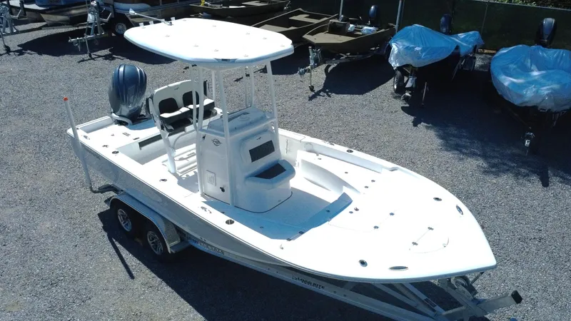 Slide: The Image of 2025 Tidewater 2210 Carolina Bay boat on trailer in a gravel lot. - 1
