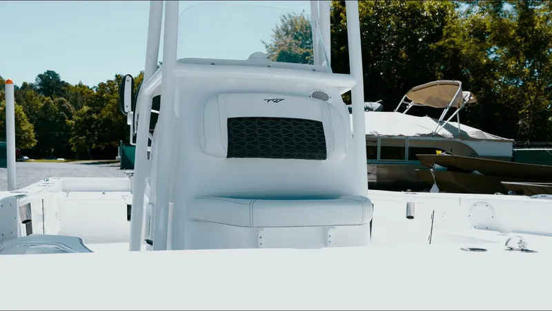 Slide: The Image of 2025 Tidewater 2210 Carolina Bay boat, white interior, docked with trees in the background. - 19