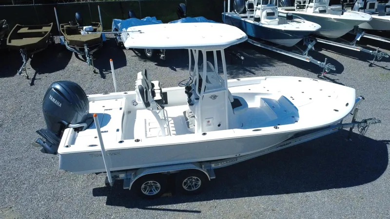 Slide: The Image of 2025 Tidewater 2210 Carolina Bay boat on trailer, parked in a marina. - 2