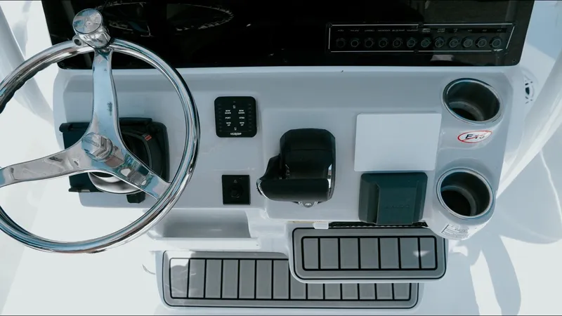 Slide: The Image of Steering console of 2025 Tidewater 2210 Carolina Bay boat with modern controls and cup holders. - 21