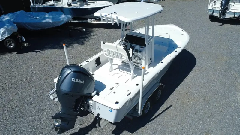 Slide: The Image of 2025 Tidewater 2210 Carolina Bay boat with Yamaha engine, parked on gravel. - 3