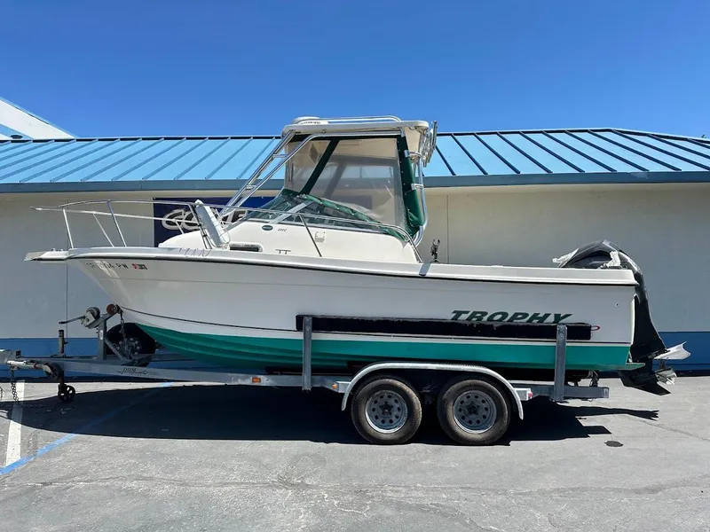 Slide: The Image of 2002 Trophy Walkaround boat on trailer, parked outdoors under clear blue sky. - 0