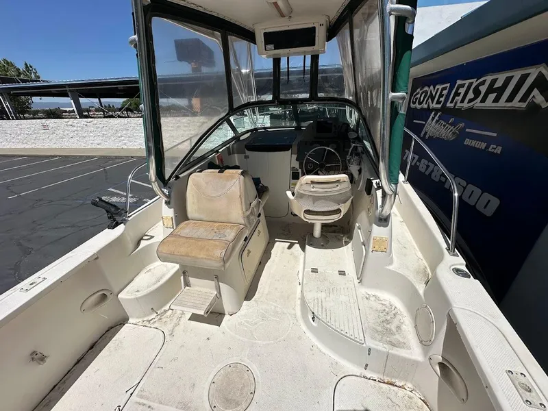 Slide: The Image of 2002 Trophy Walkaround boat interior with seating and steering wheel, parked outdoors. - 11