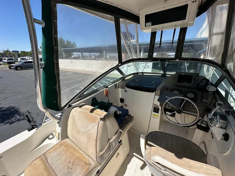 Slide: The Image of Interior of a 2002 Trophy Walkaround boat showing steering wheel and seating area. - 15