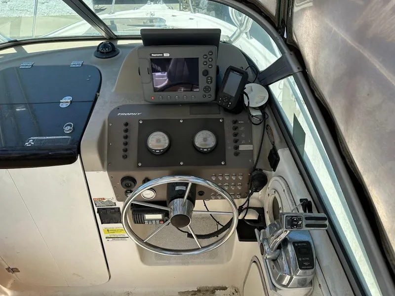 Slide: The Image of 2002 Trophy Walkaround boat dashboard with steering wheel and navigation equipment. - 19