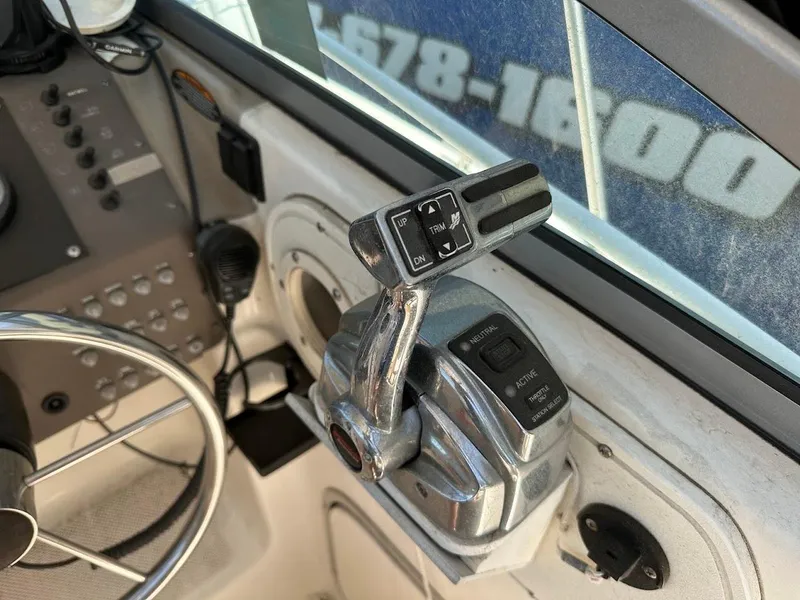 Slide: The Image of Control panel of a 2002 Trophy Walkaround boat with steering wheel and throttle lever. - 24