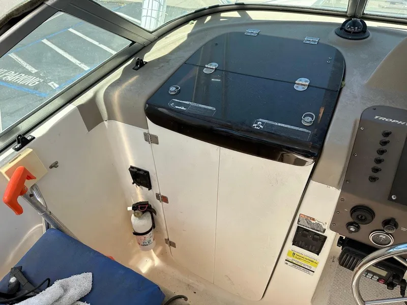 Slide: The Image of Interior of a 2002 Trophy Walkaround boat, featuring control panel and storage area. - 25