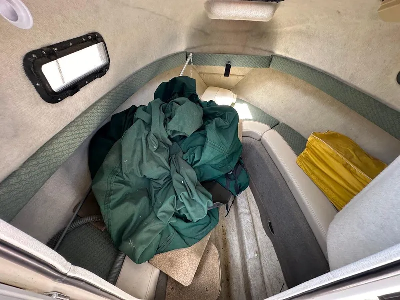 Slide: The Image of 2002 Trophy Walkaround cabin interior with green and yellow gear stored inside. - 27