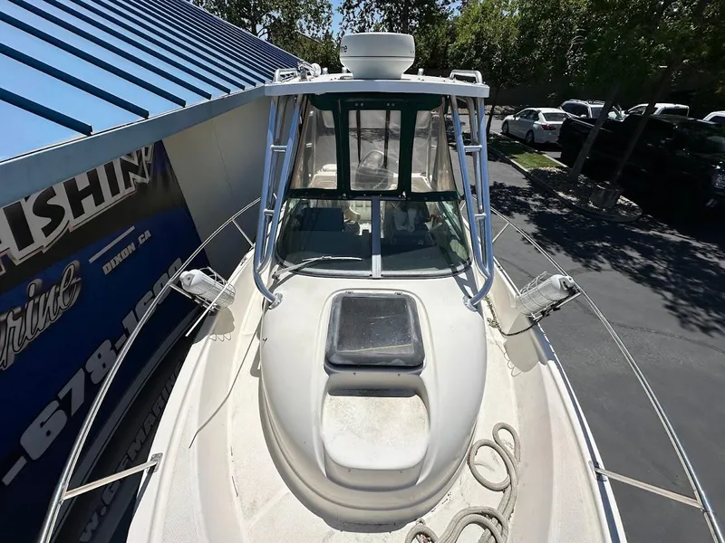 Slide: The Image of 2002 Trophy Walkaround boat with cabin, docked near a blue-roofed building. - 29