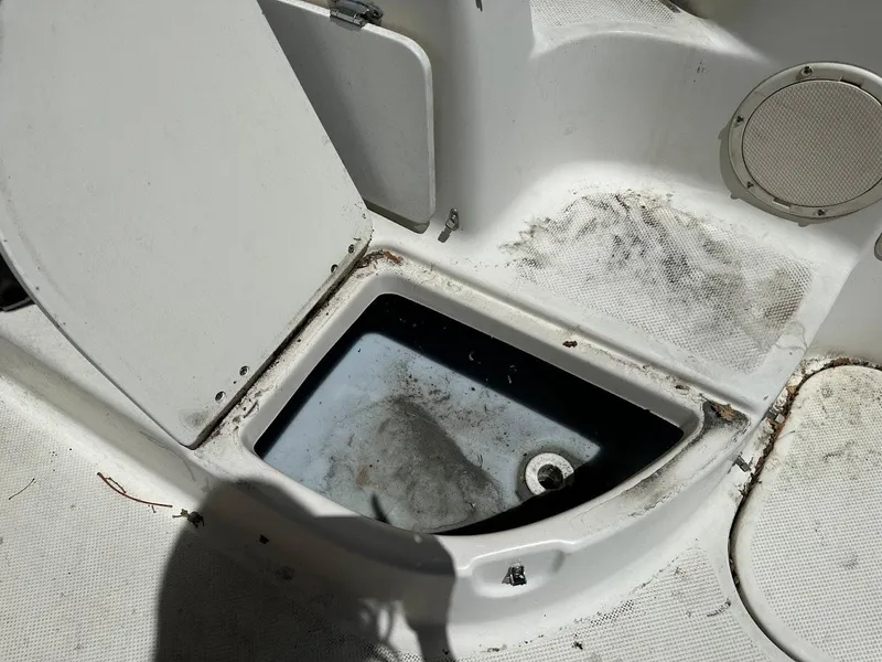Slide: The Image of Open storage compartment on 2002 Trophy Walkaround boat, showing interior details and wear. - 30