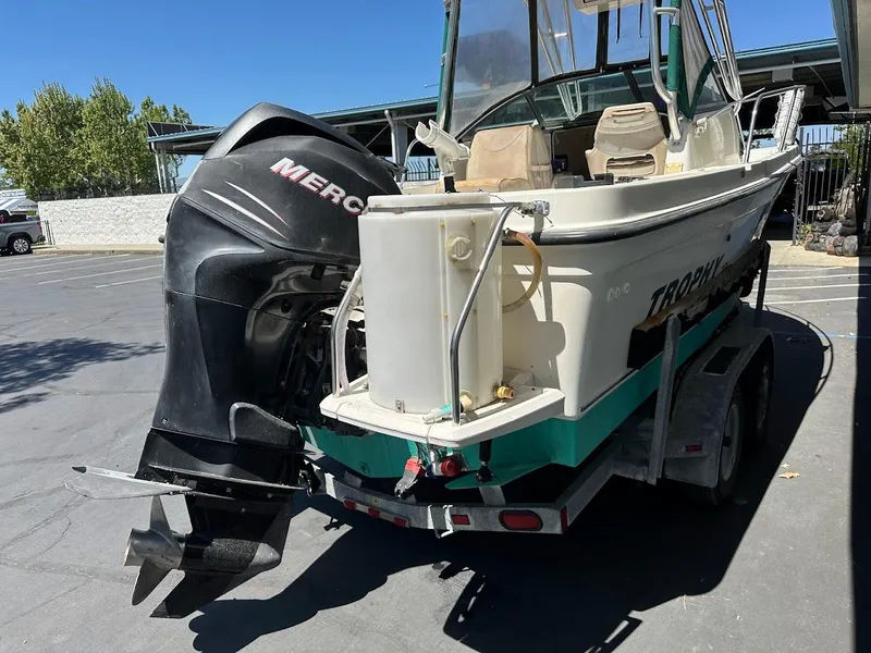 Slide: The Image of 2002 Trophy Walkaround boat with Mercury outboard motor on a trailer in a parking lot. - 31
