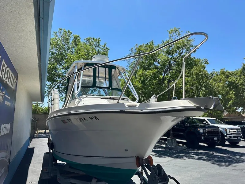 Slide: The Image of 2002 Trophy Walkaround boat on trailer, parked outdoors under clear blue sky. - 4