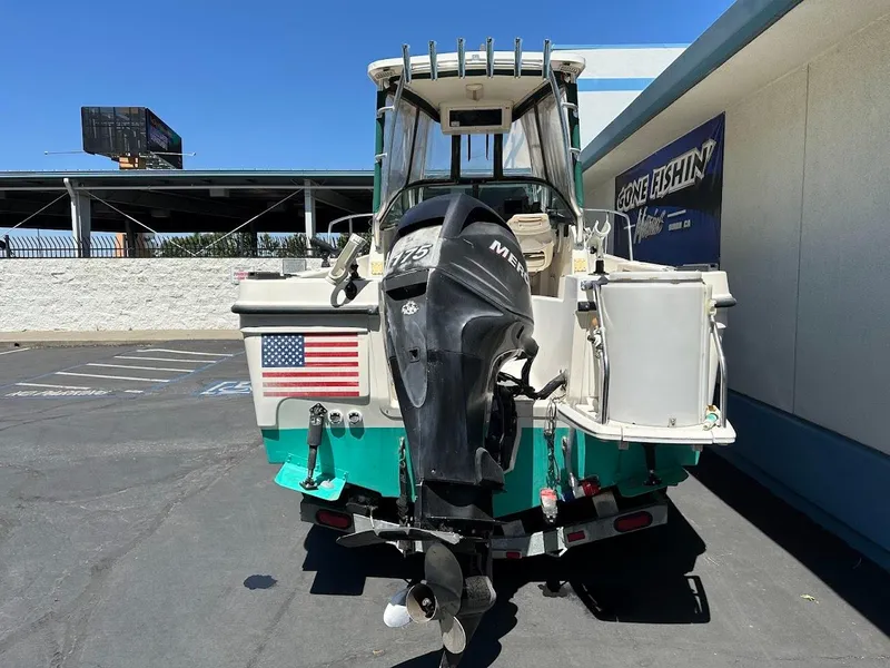 Slide: The Image of 2002 Trophy Walkaround boat with outboard motor, American flag, parked outdoors. - 8