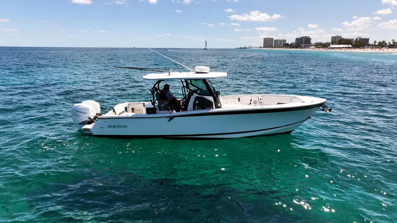 Slide: The Image of 2020 Blackfin 332 CC boat on clear blue ocean near coastline. - 1