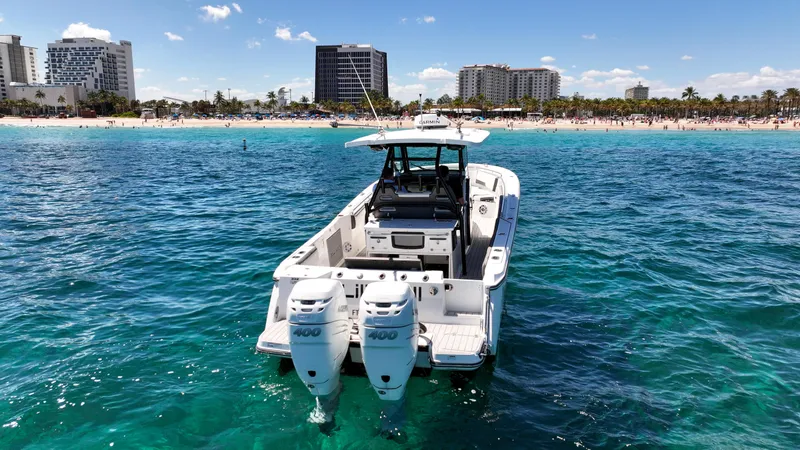 Slide: The Image of 2020 Blackfin 332 CC boat on clear blue water near a beach with buildings. - 10