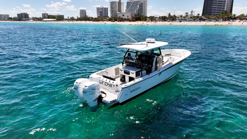 Slide: The Image of 2020 Blackfin 332 CC boat on clear blue water near a city shoreline. - 11