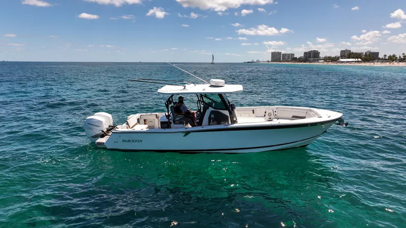 Slide: The Image of 2020 Blackfin 332 CC boat on clear blue ocean near coastline. - 2