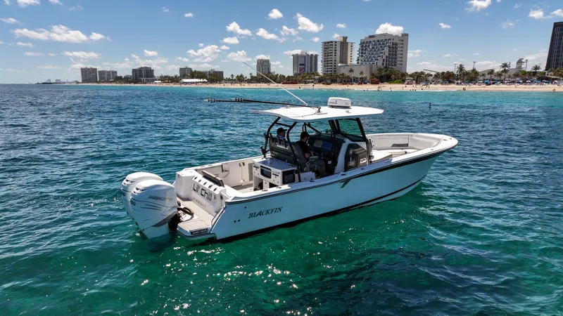Slide: The Image of 2020 Blackfin 332 CC boat on clear blue water near a city shoreline. - 9