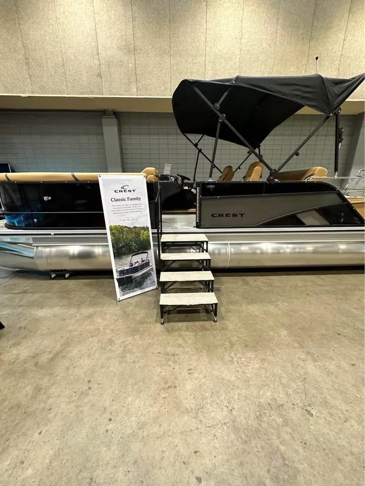 Slide: The Image of 2025 Crest Classic 240 pontoon boat with canopy displayed indoors. - 8