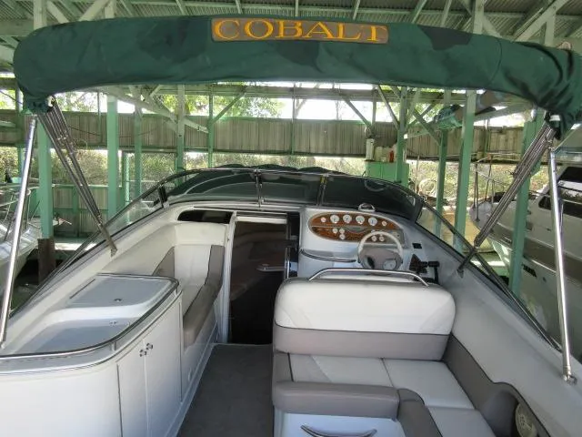 Slide: The Image of 1998 Cobalt 293 boat interior with canopy, featuring seating and control panel. - 11
