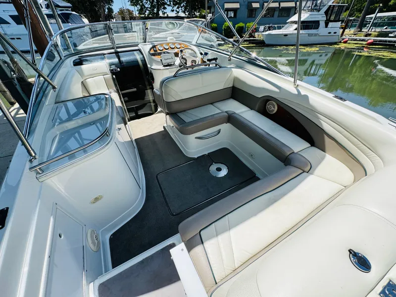 Slide: The Image of 1998 Cobalt 293 boat interior with beige seating and steering console, docked at marina. - 13