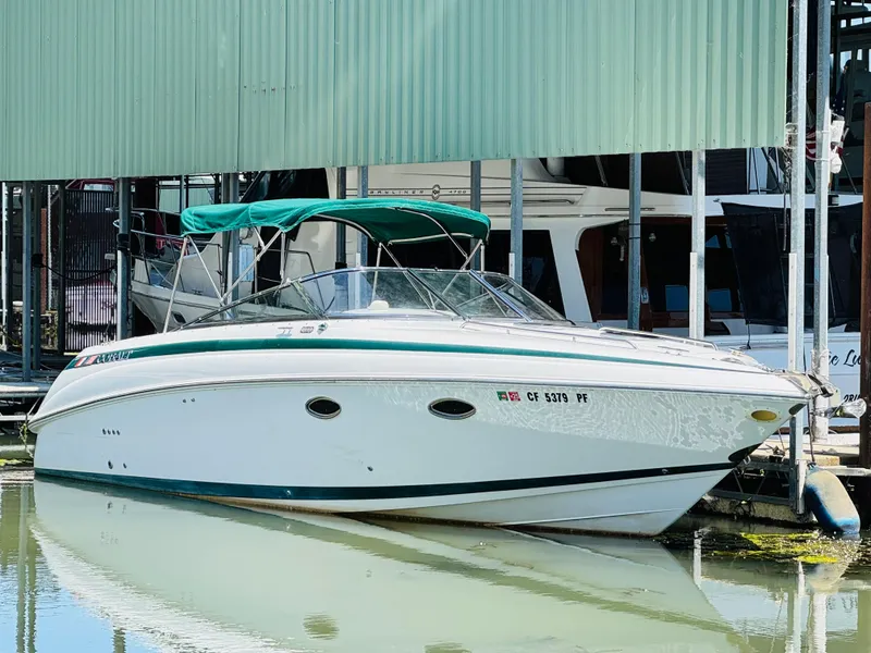 Slide: The Image of 1998 Cobalt 293 boat docked in marina, featuring green canopy and sleek white hull. - 2