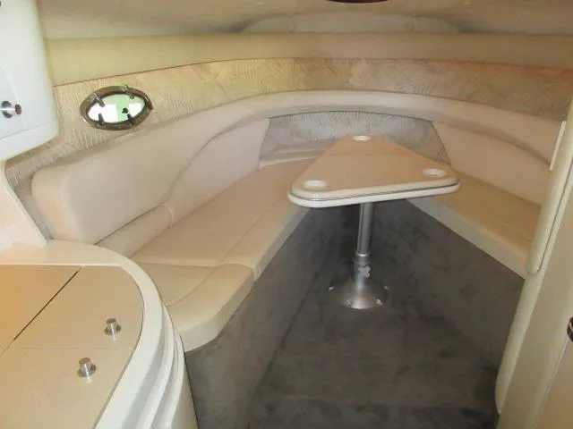 Slide: The Image of 1998 Cobalt 293 boat interior with beige seating and triangular table. - 34