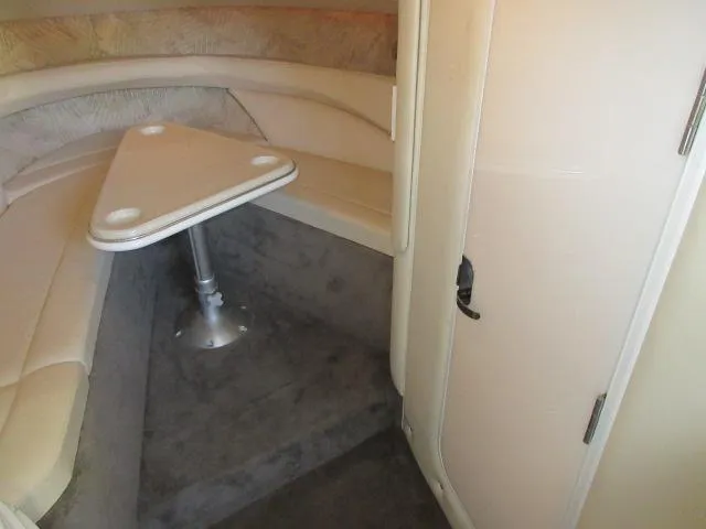 Slide: The Image of 1998 Cobalt 293 cabin interior with triangular table and cushioned seating. - 36