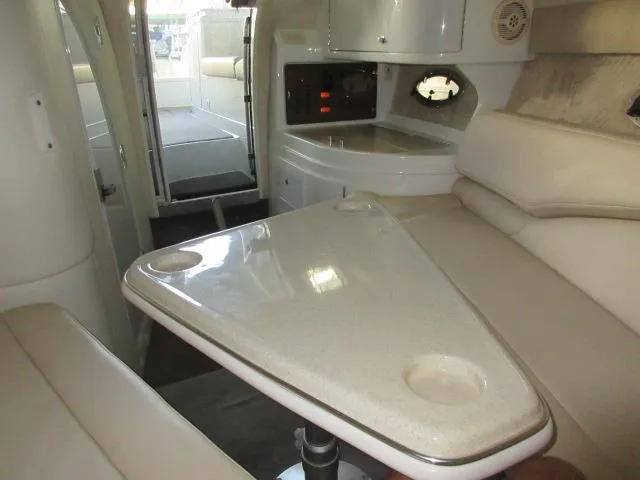 Slide: The Image of Interior of a 1998 Cobalt 293 boat with beige seating and a triangular table. - 37