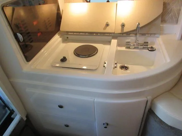 Slide: The Image of Compact kitchen area in a 1998 Cobalt 293 boat with stove and sink. - 38