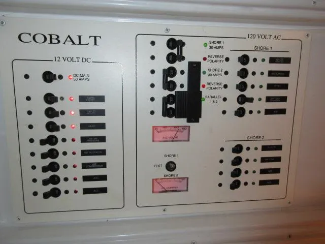 Slide: The Image of Electrical control panel of a 1998 Cobalt 293 boat, featuring 12V DC and 120V AC systems. - 42