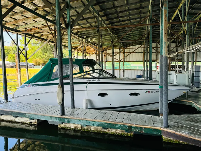 Slide: The Image of 1998 Cobalt 293 boat docked under a covered marina. - 6